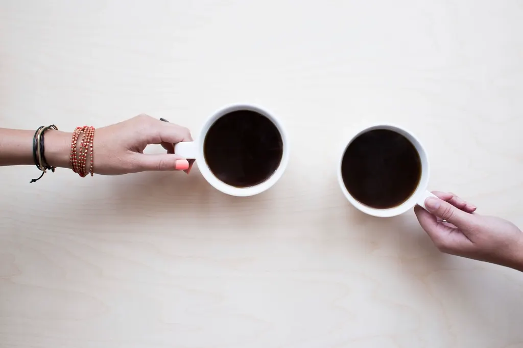 Two people in conversation over coffee